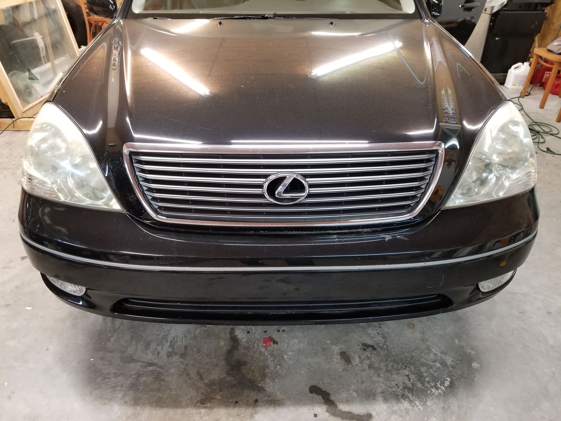 A black lexus car is parked in a garage.