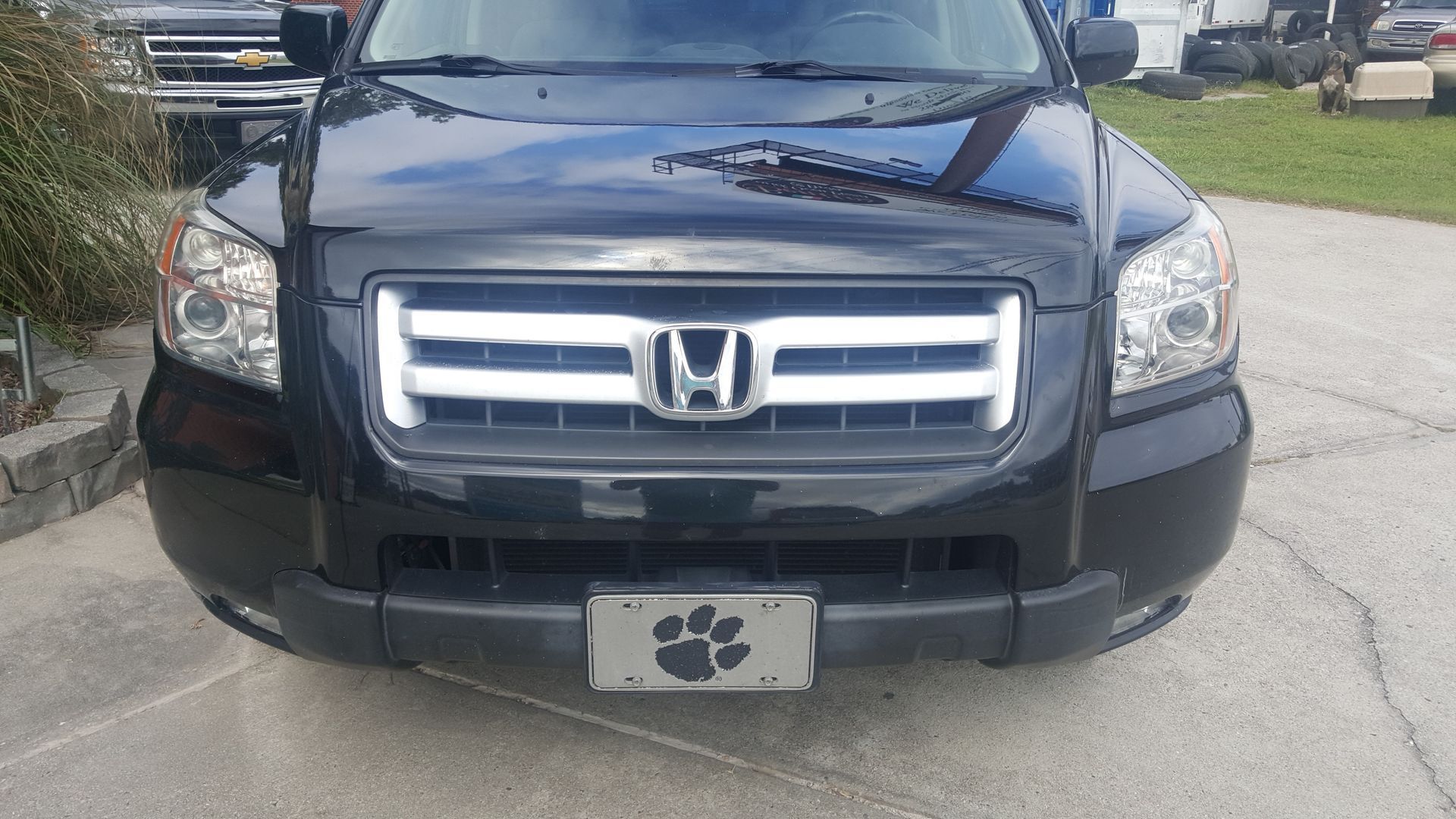 A black honda ridgeline is parked on the side of the road.
