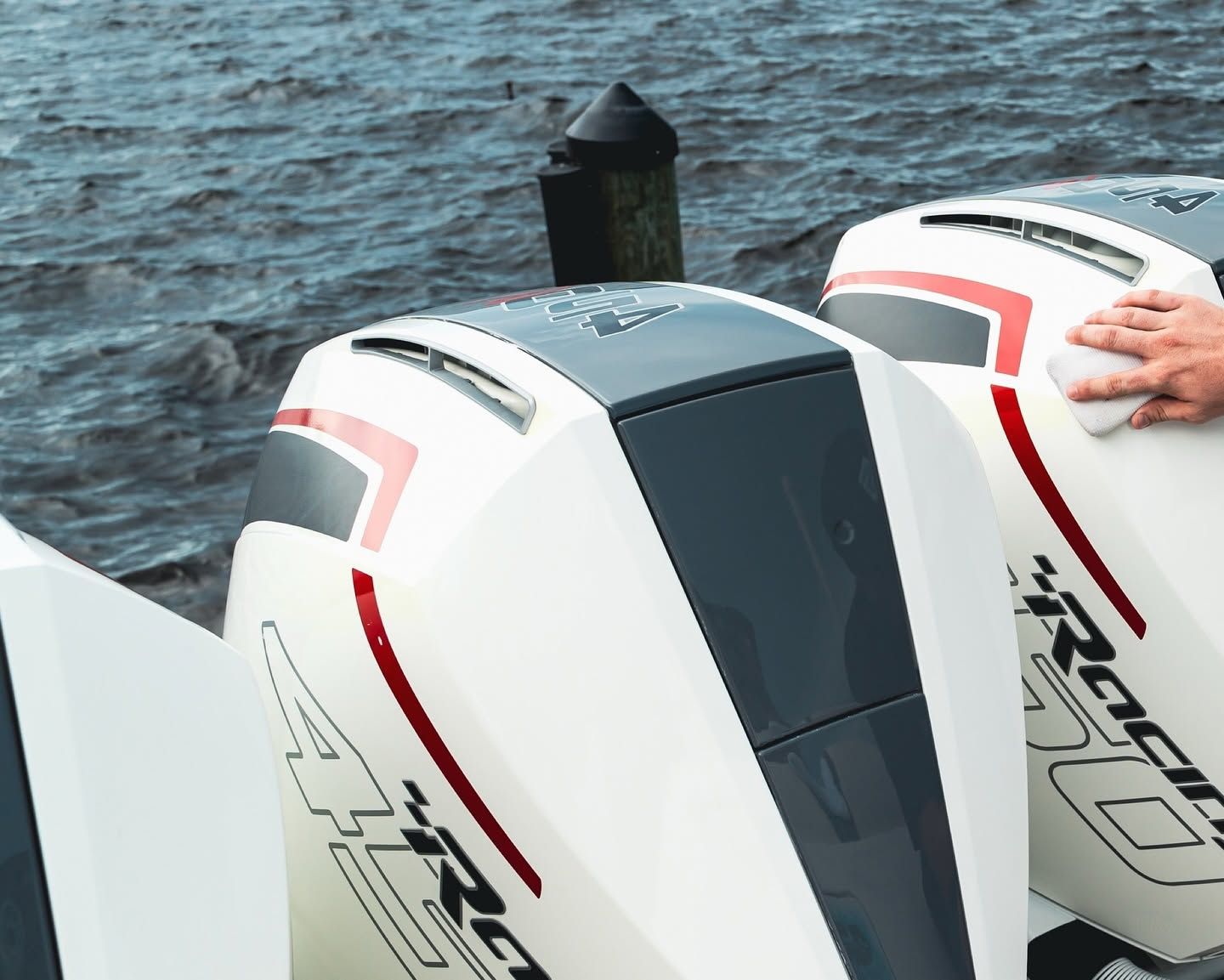 Close-up of two white and red outboard motors on water