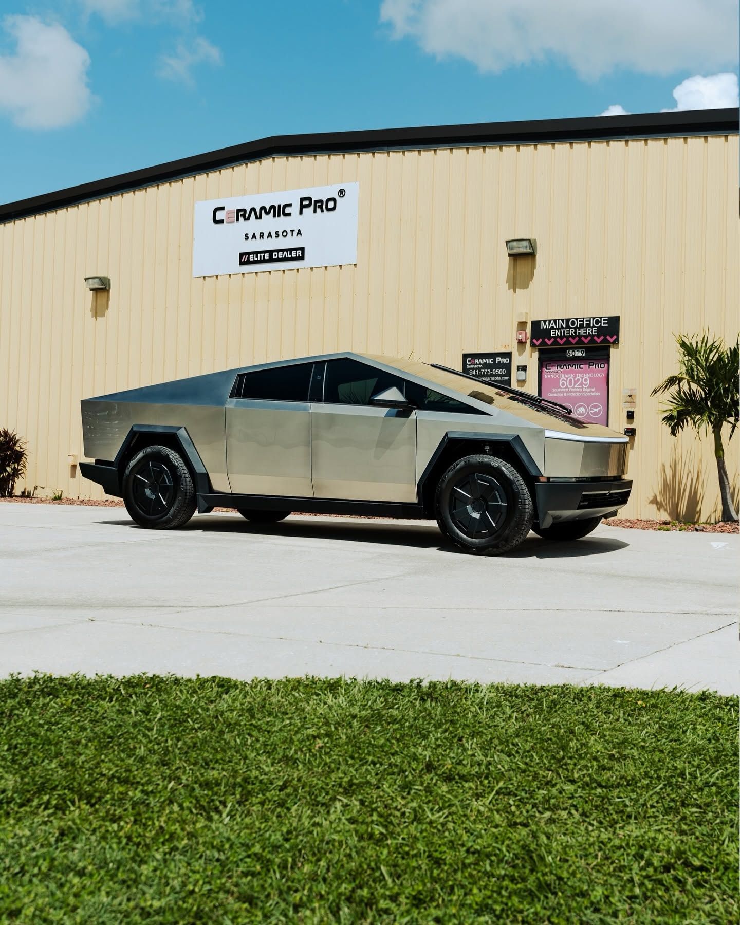 Tesla Cybertruck parked outside a beige building with a “Crime Pro” sign, on a sunny day.