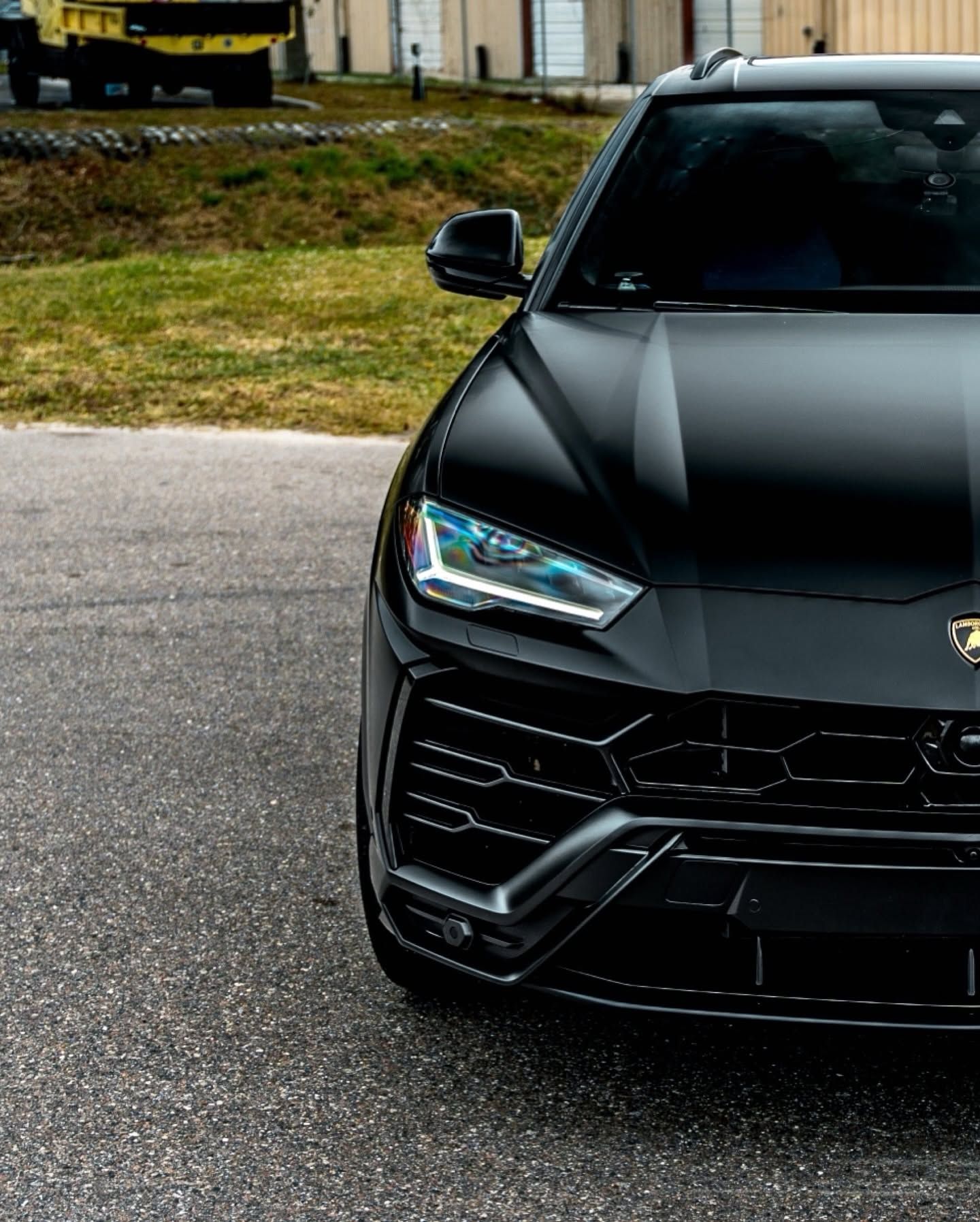 Front view of a black luxury SUV parked on pavement, with a grassy background
