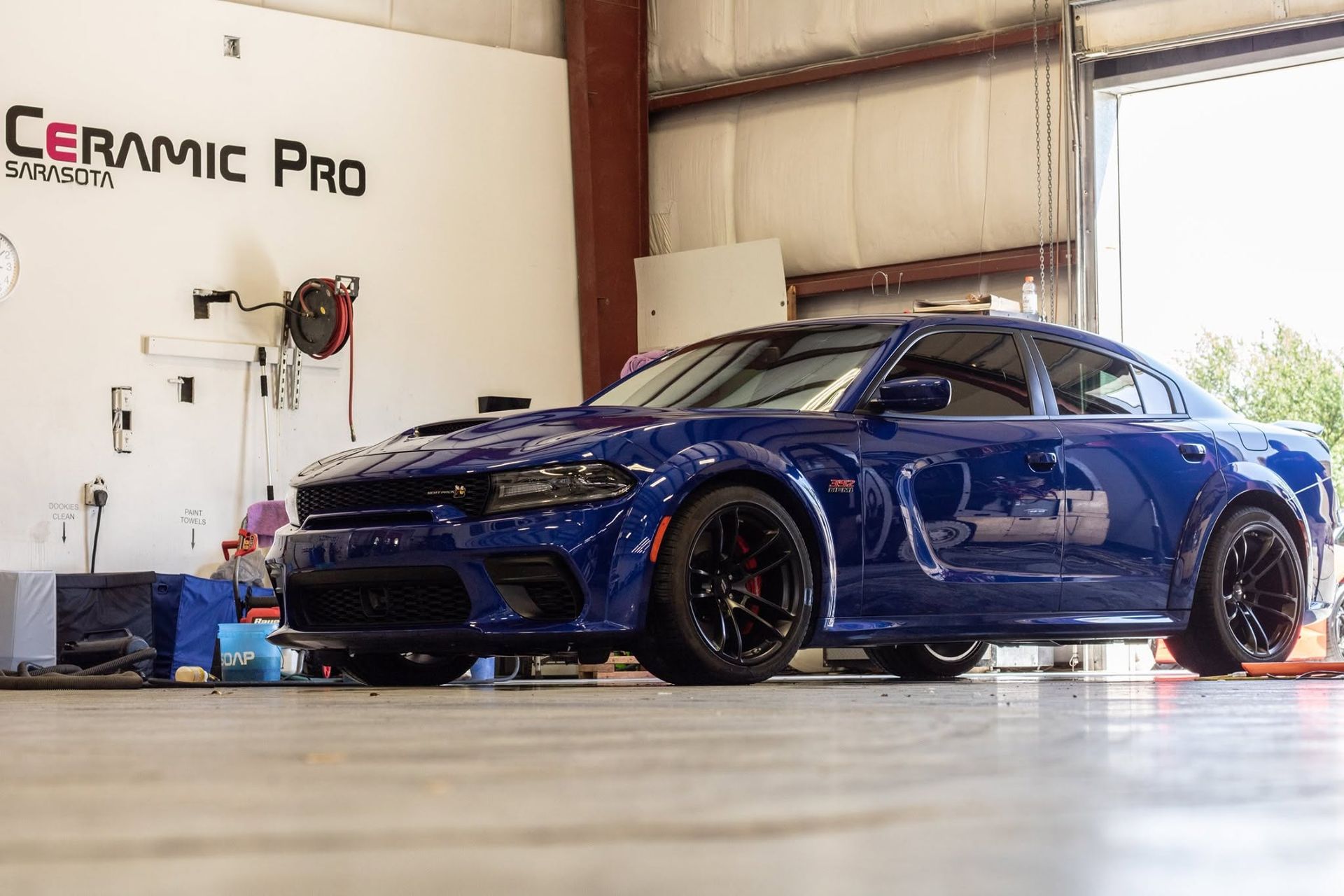 Blue sports car in a garage, parked at a Ceramic Pro detailing shop.