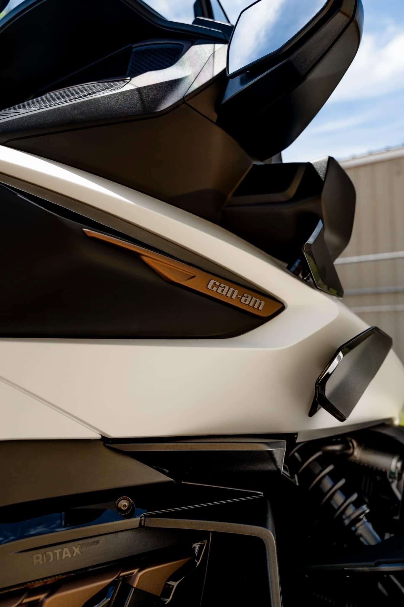 Close-up of a black and white scooter with a windshield and spring suspension