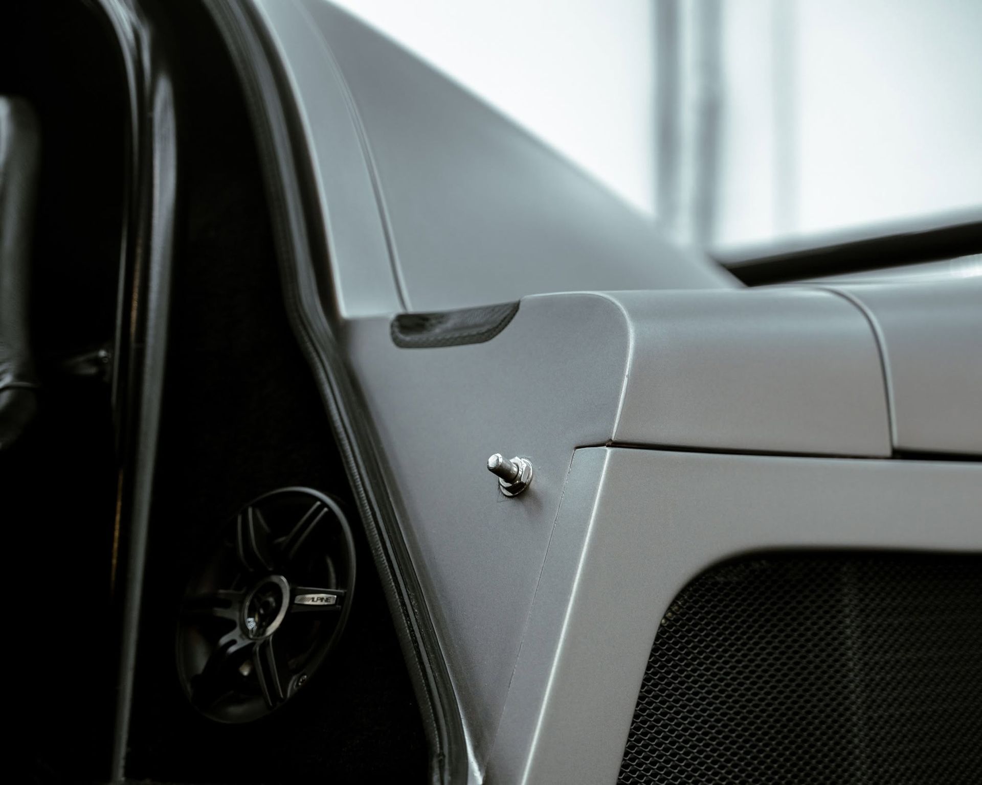 Close-up of a gray car interior with a steering wheel and dashboard detail