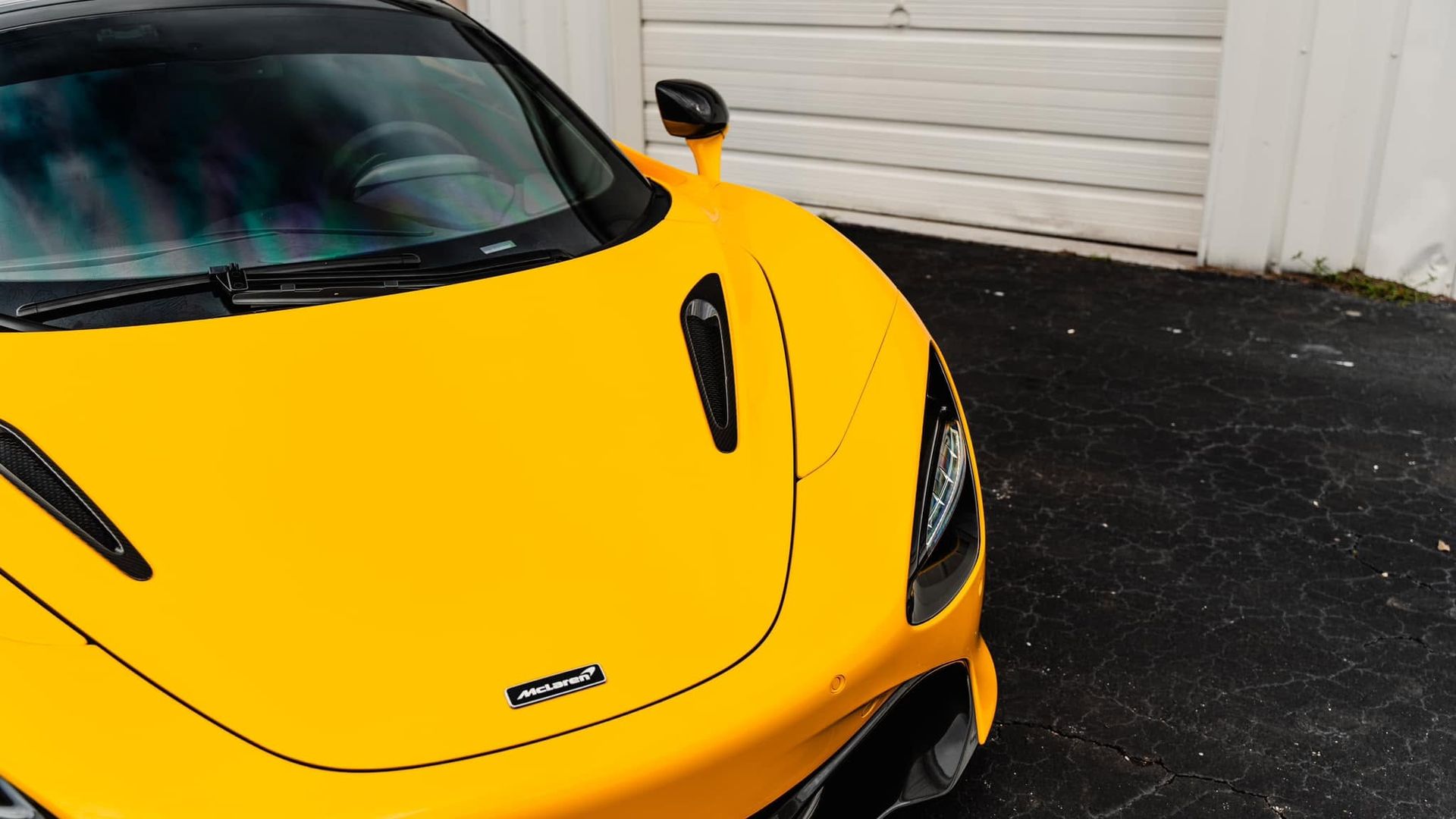 Yellow sports car parked in front of a white garage door