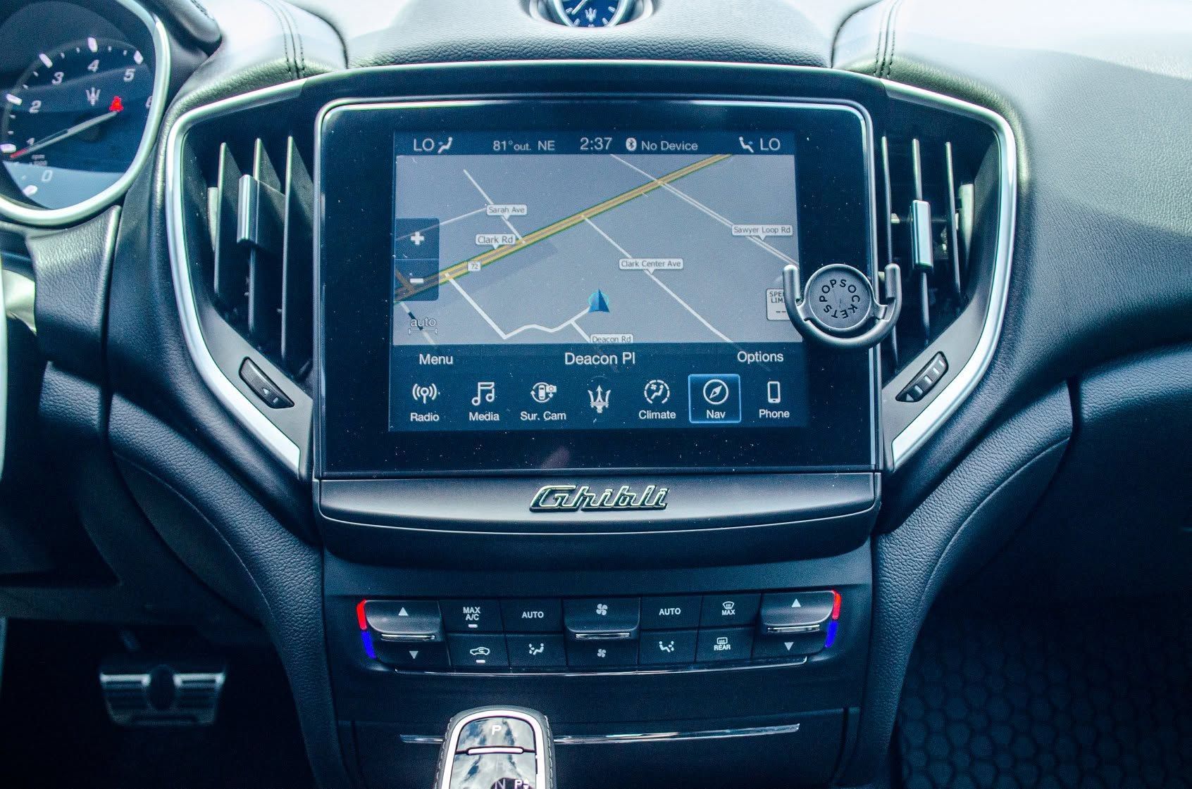 Car dashboard with central touchscreen navigation display and climate controls, shown from the driver’s seat