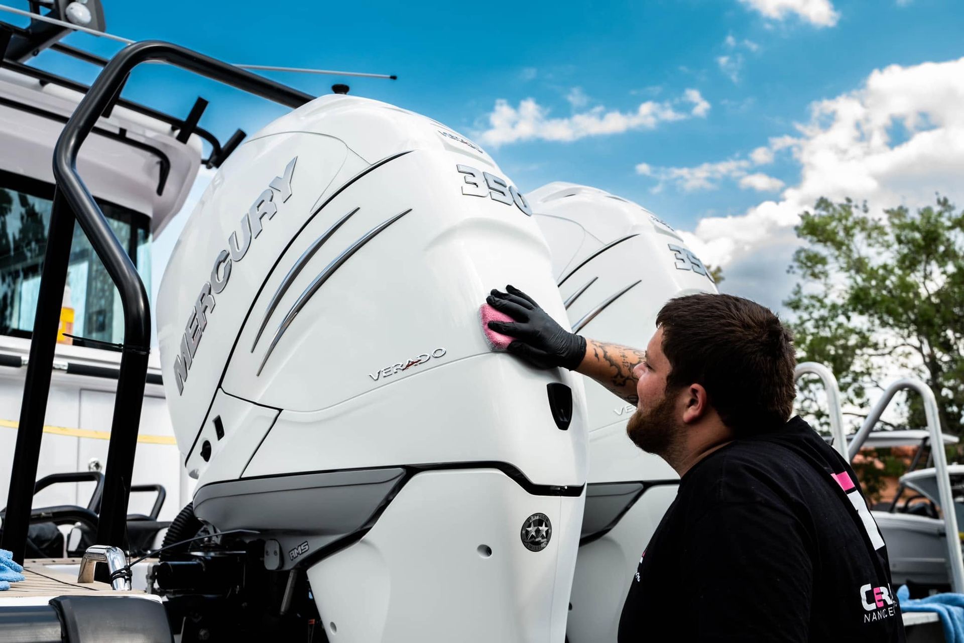 Worker inspecting white industrial machinery outdoors under a blue sky