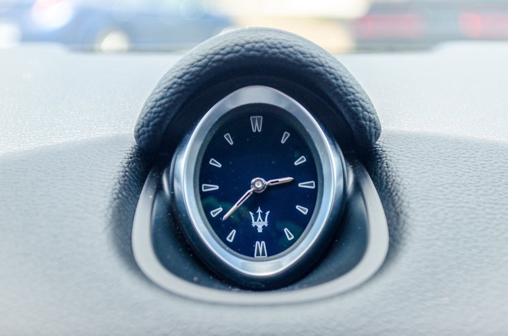 Blue car dashboard clock in a silver oval frame