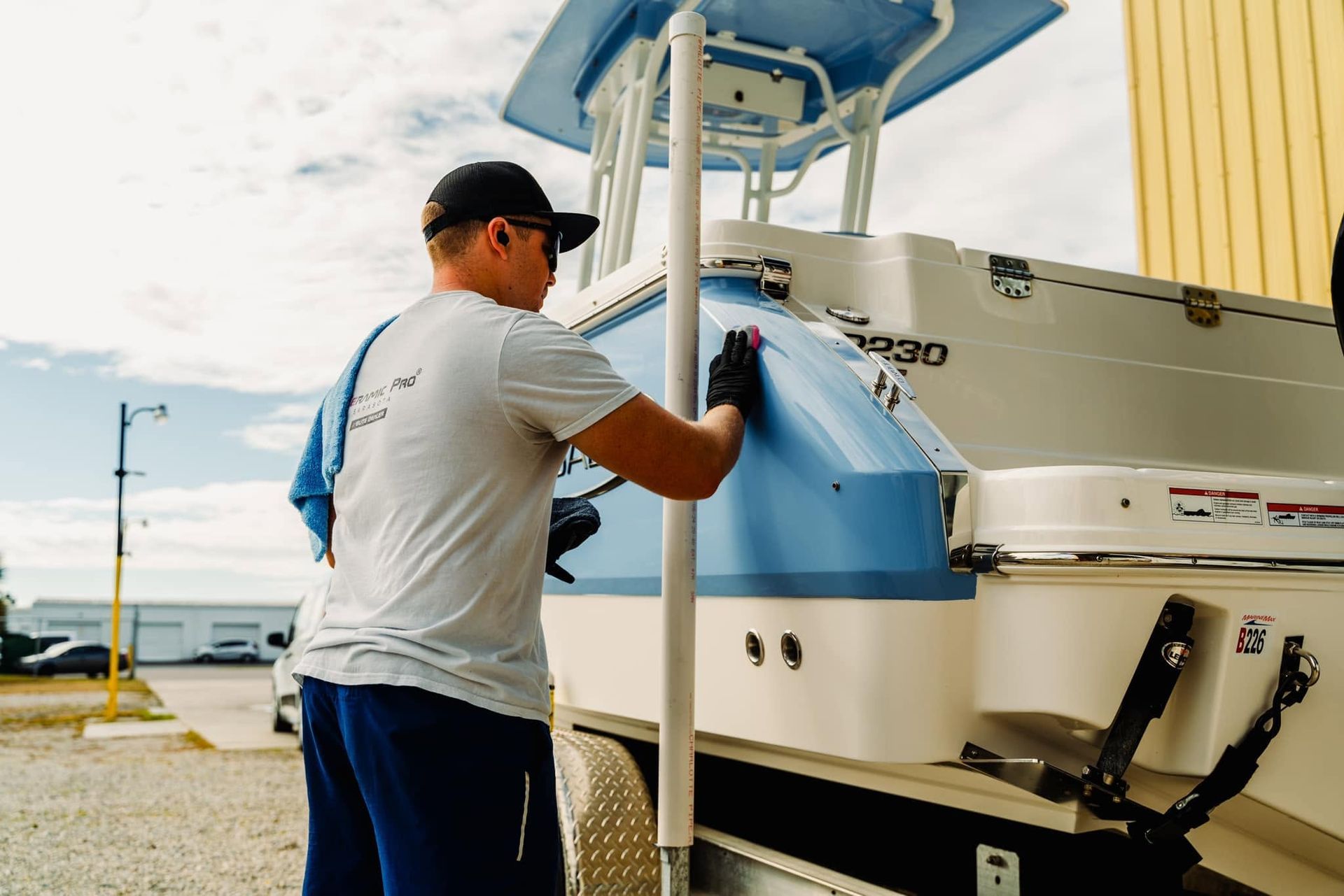 Man fueling a large white and blue boat at a dock