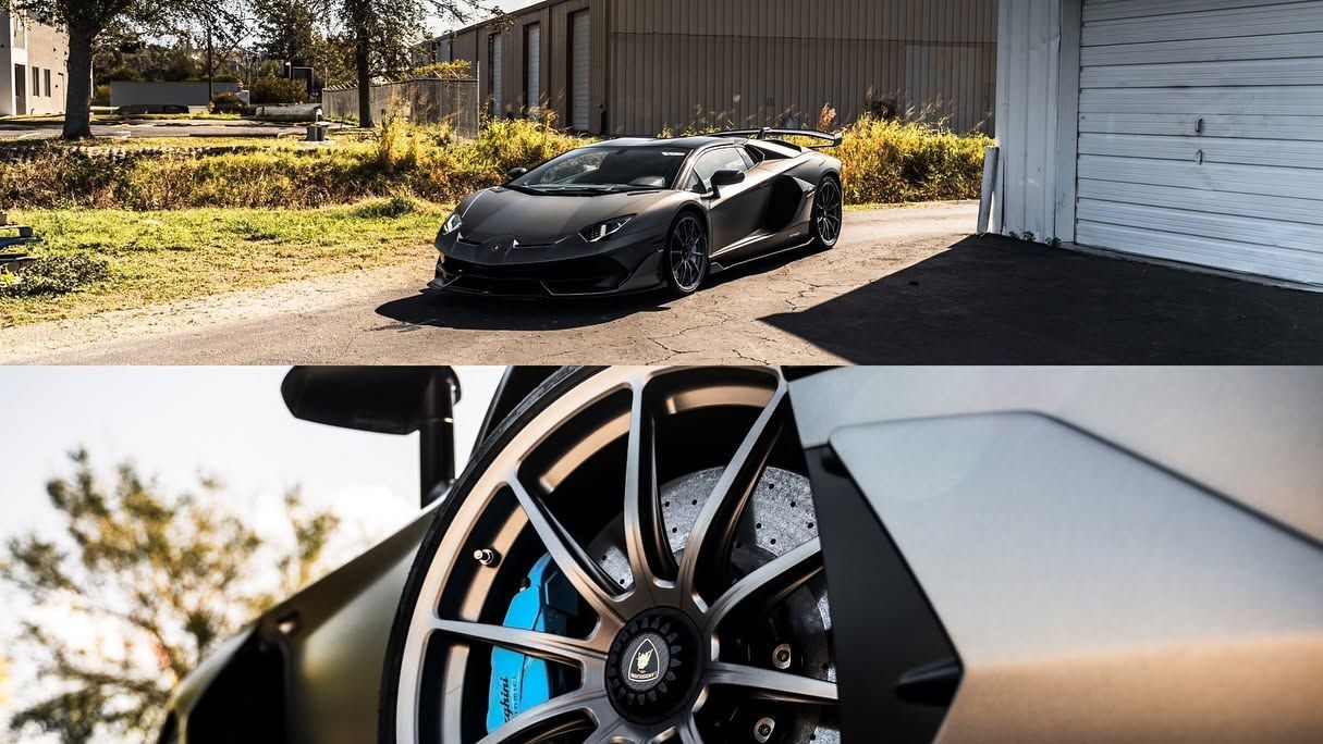 Black sports car in driveway; close-up of alloy wheel and blue brake caliper.