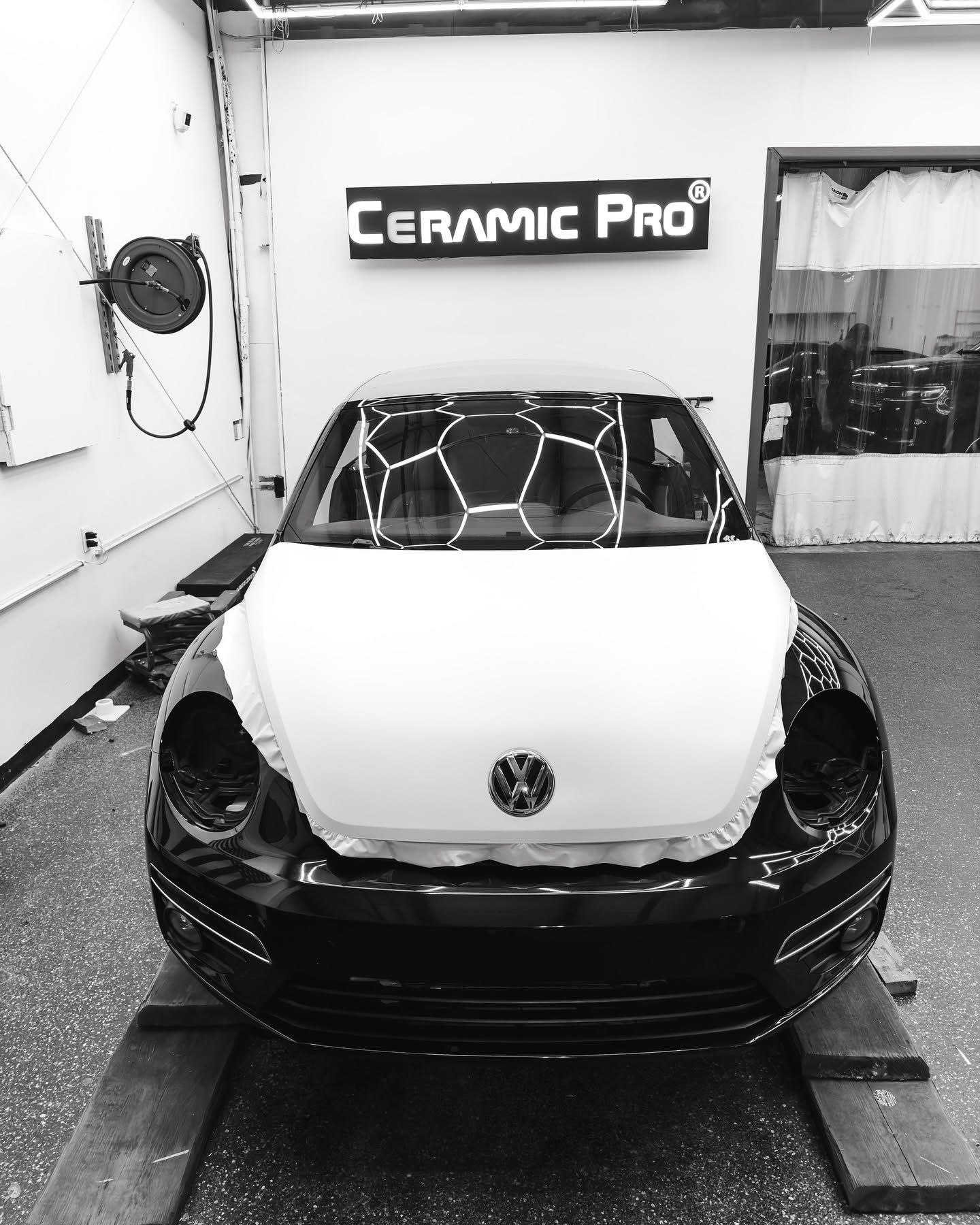 Volkswagen car in a detailing shop with a Ceramic Pro sign overhead