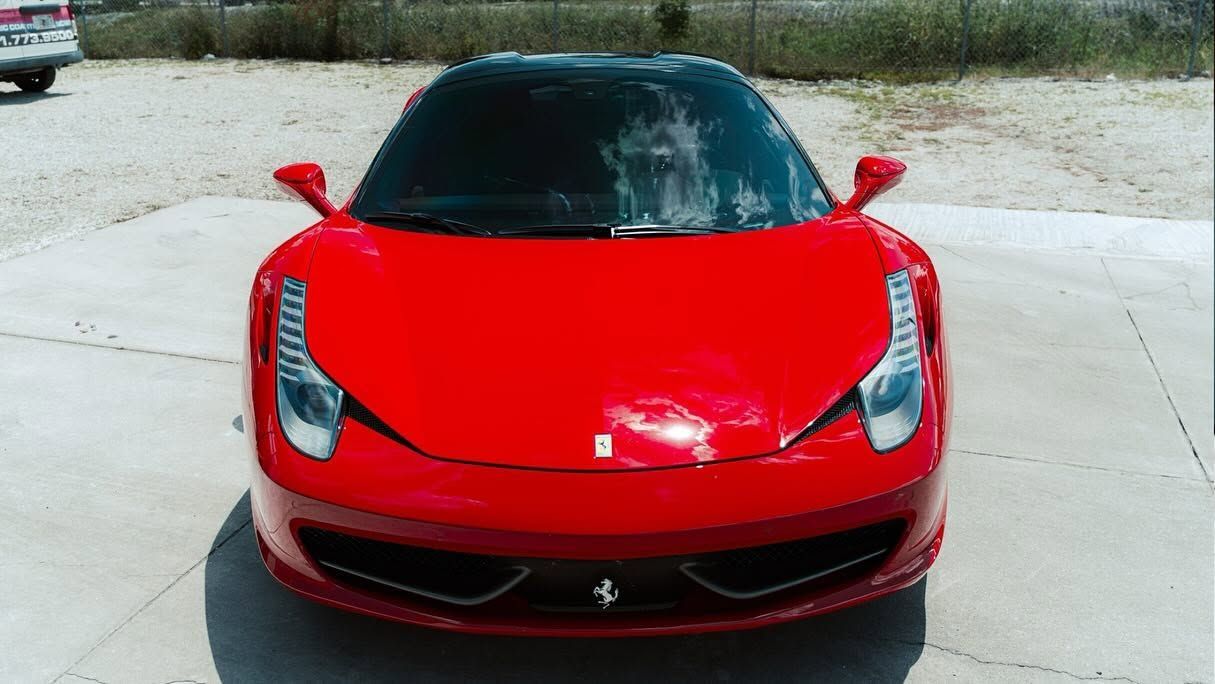 Front view of a red sports car parked on a driveway.