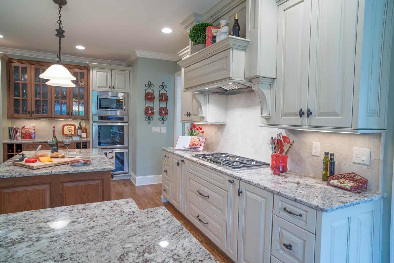 Bright kitchen with light blue cabinets, granite countertops, and stainless appliances.