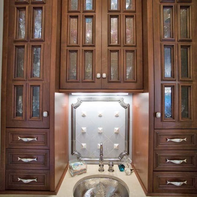 Wood-paneled bathroom vanity with mirrored cabinet, sink, and built-in storage drawers