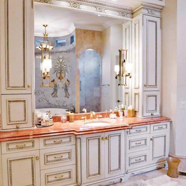Elegant white-and-gold bathroom vanity with large mirror and peach marble countertop