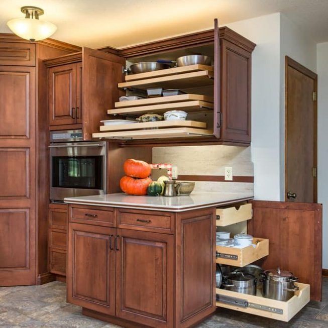 Kitchen with dark wood cabinets, open shelves, countertops, pumpkins, and a pull-out pantry drawer.