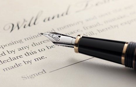 Last will and testament document with closeup on fountain pen with signature line