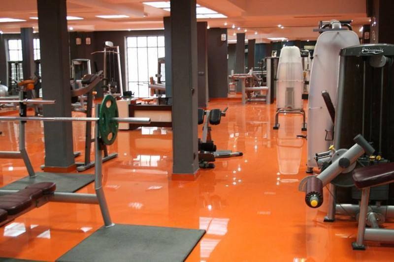 A gym with orange floors and lots of equipment