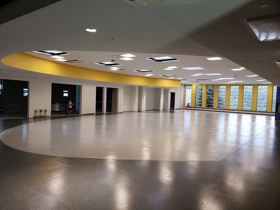 A large empty room with a circular floor and yellow walls