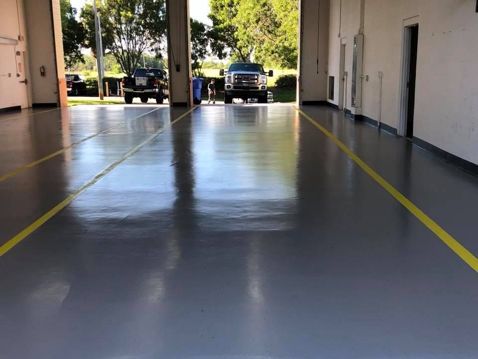 Two cars are parked in a garage with a yellow line on the floor