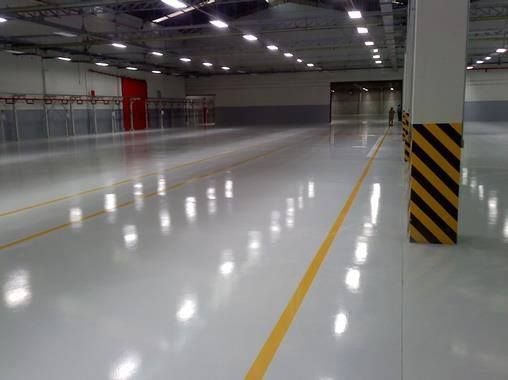 A large empty warehouse with a yellow line on the floor.
