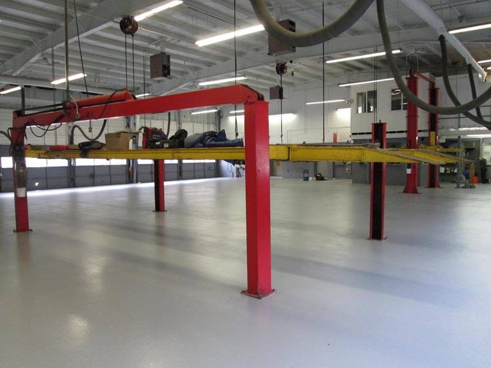 A large empty garage with red and yellow lifts
