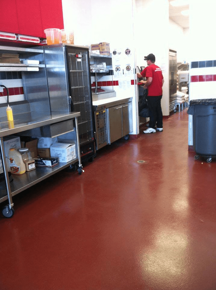 A man in a red shirt is working in a kitchen
