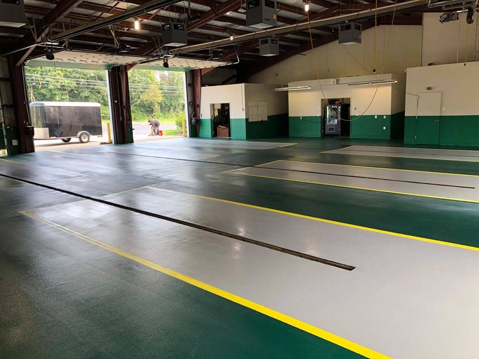 A large garage with green and white walls and a yellow line on the floor.