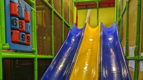 a blue and yellow slide in a playground 