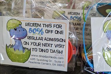 A sign that says redeem this for 50 % off one regular admission on your next visit to dino dash