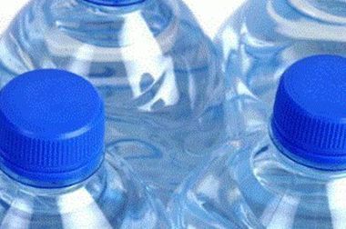 Three bottles of water with blue caps on a white background.