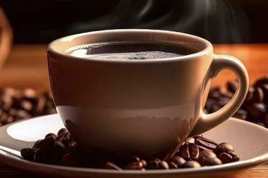 A cup of coffee is sitting on a saucer surrounded by coffee beans.