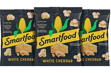 Three bags of smartfood white cheddar popcorn are sitting next to each other.