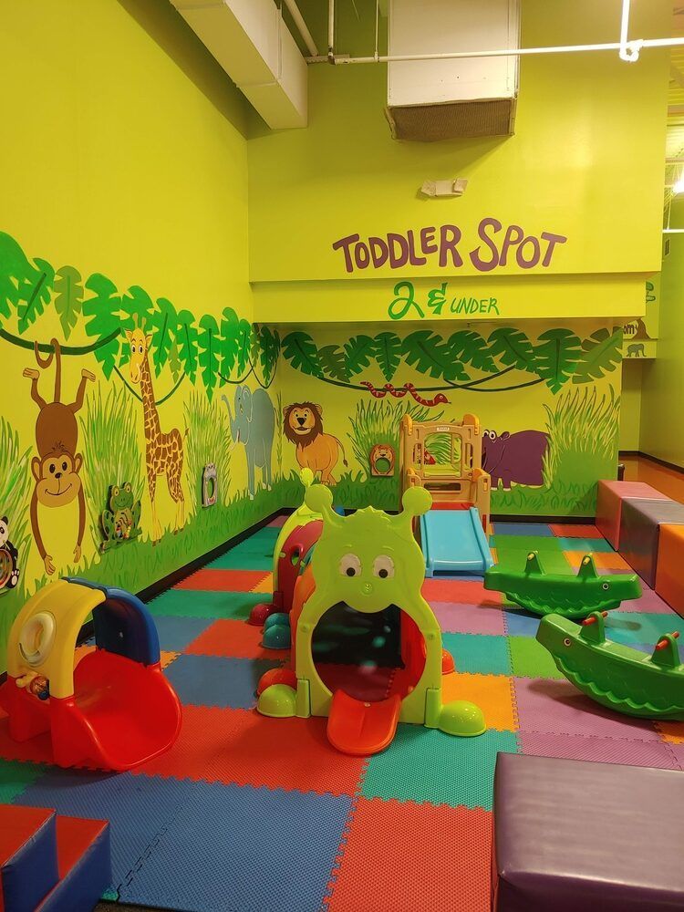 A toddler room with lots of toys and a sign that says toddler spot