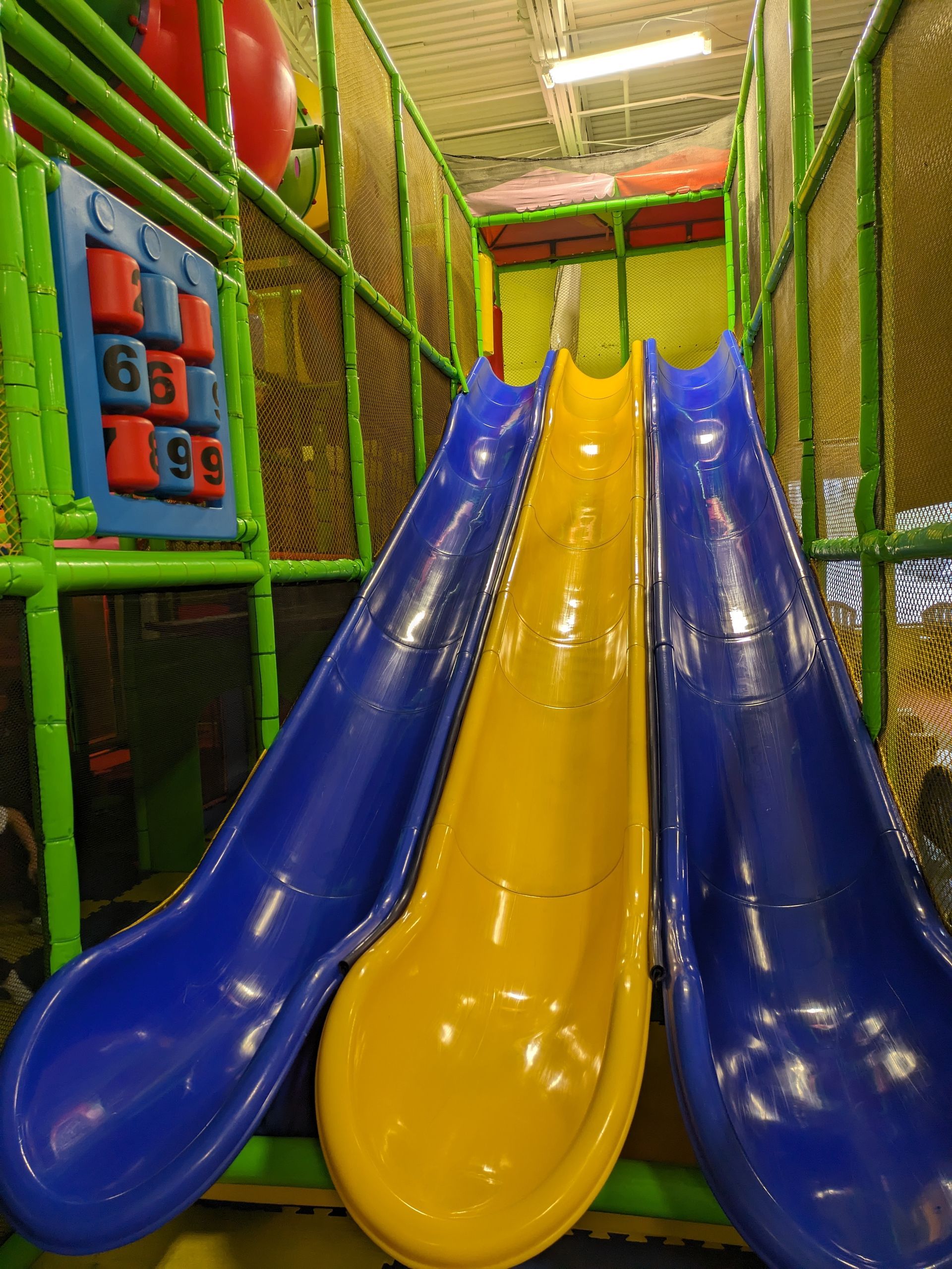 A blue and yellow slide in an indoor playground