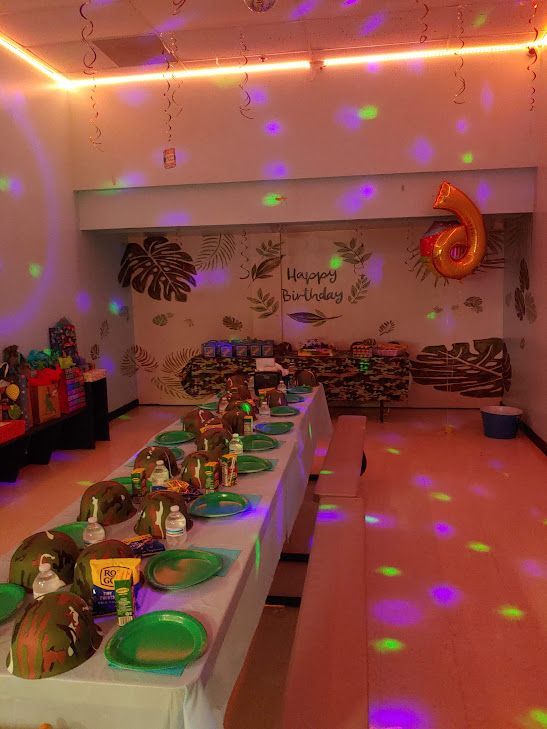 A room decorated for a birthday party with a long table and plates.