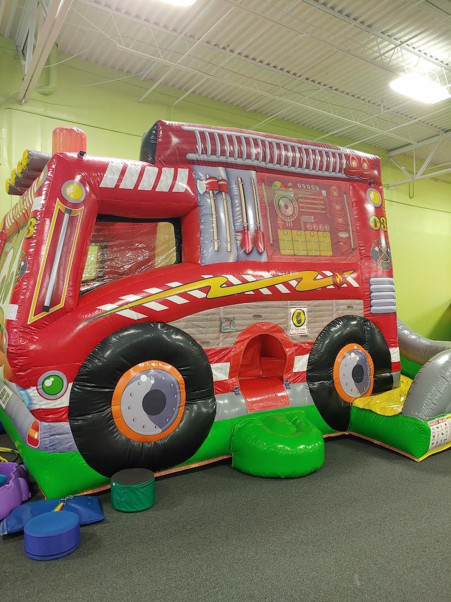 A large inflatable fire truck is sitting in a room.