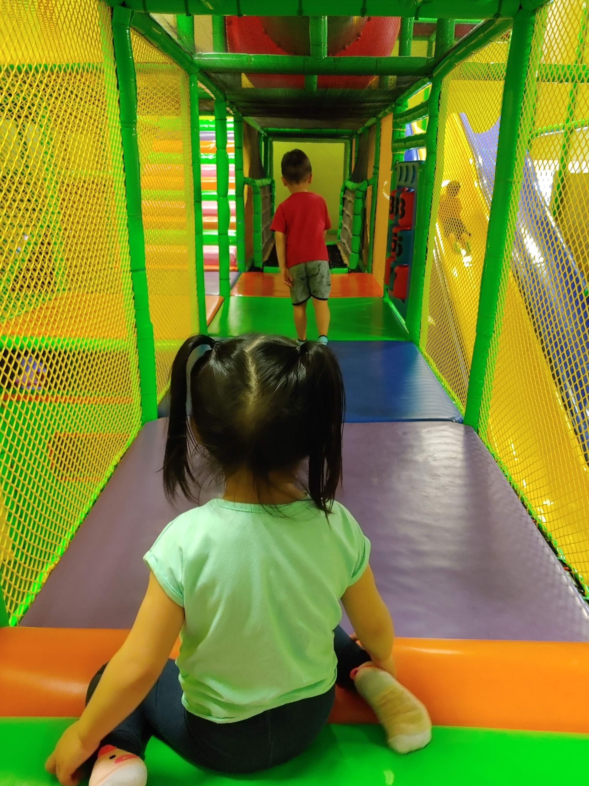 A little girl is sitting on a slide in a playground