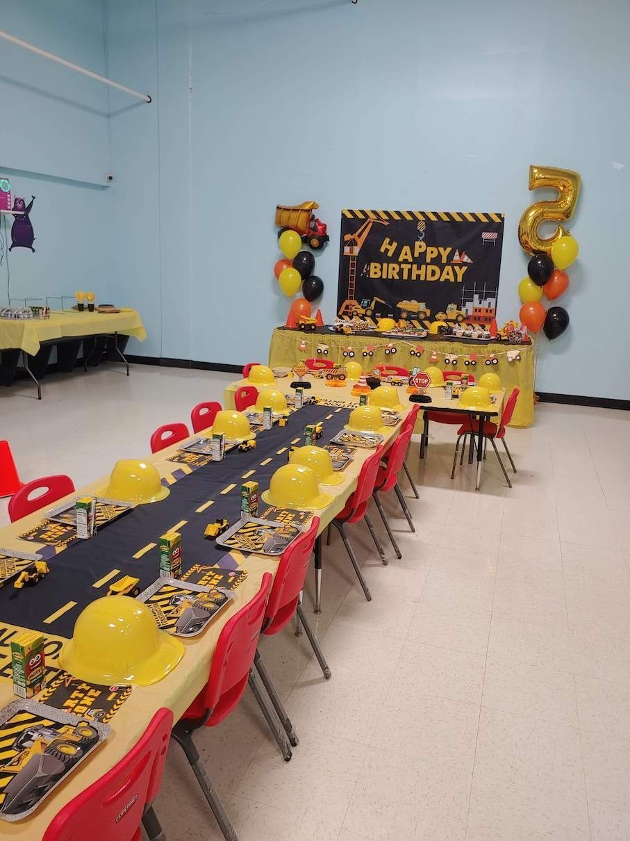 A room decorated for a birthday party with tables and chairs