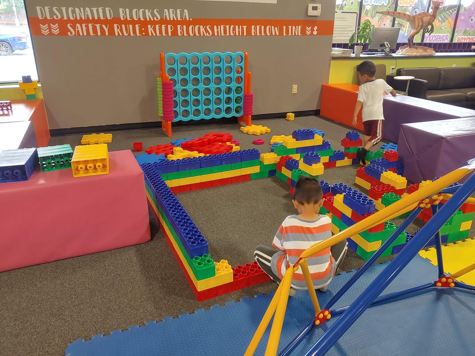A child is playing in a room with lots of lego blocks