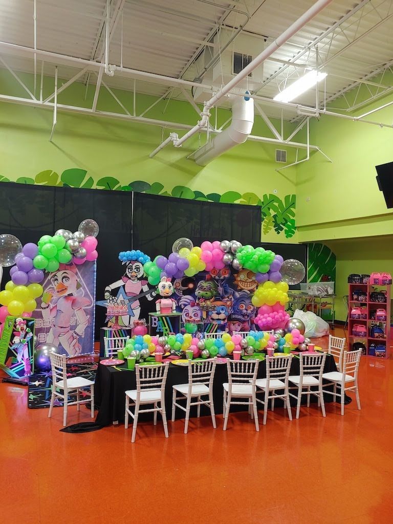A room filled with tables and chairs and balloons
