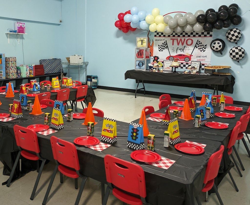 A room with tables and chairs set up for a birthday party