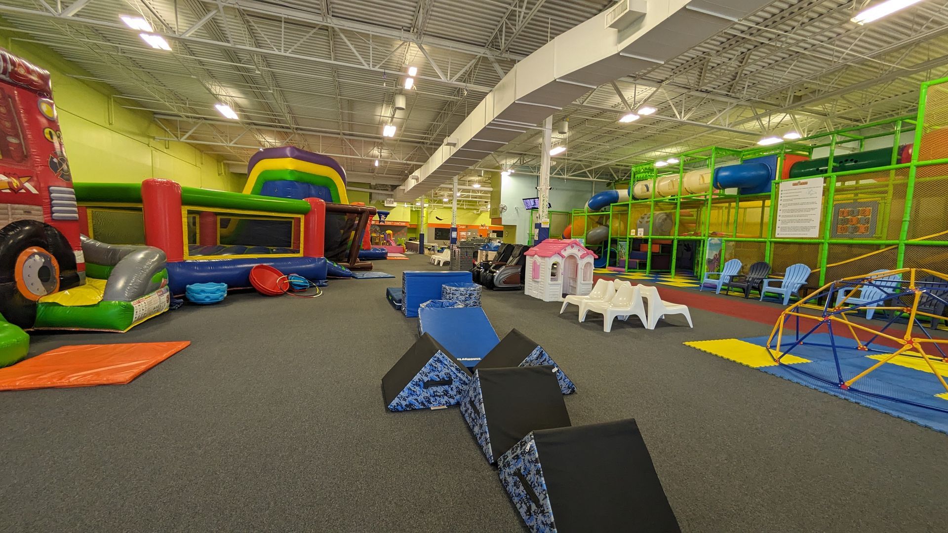 A large indoor playground with lots of toys and a bouncy house.