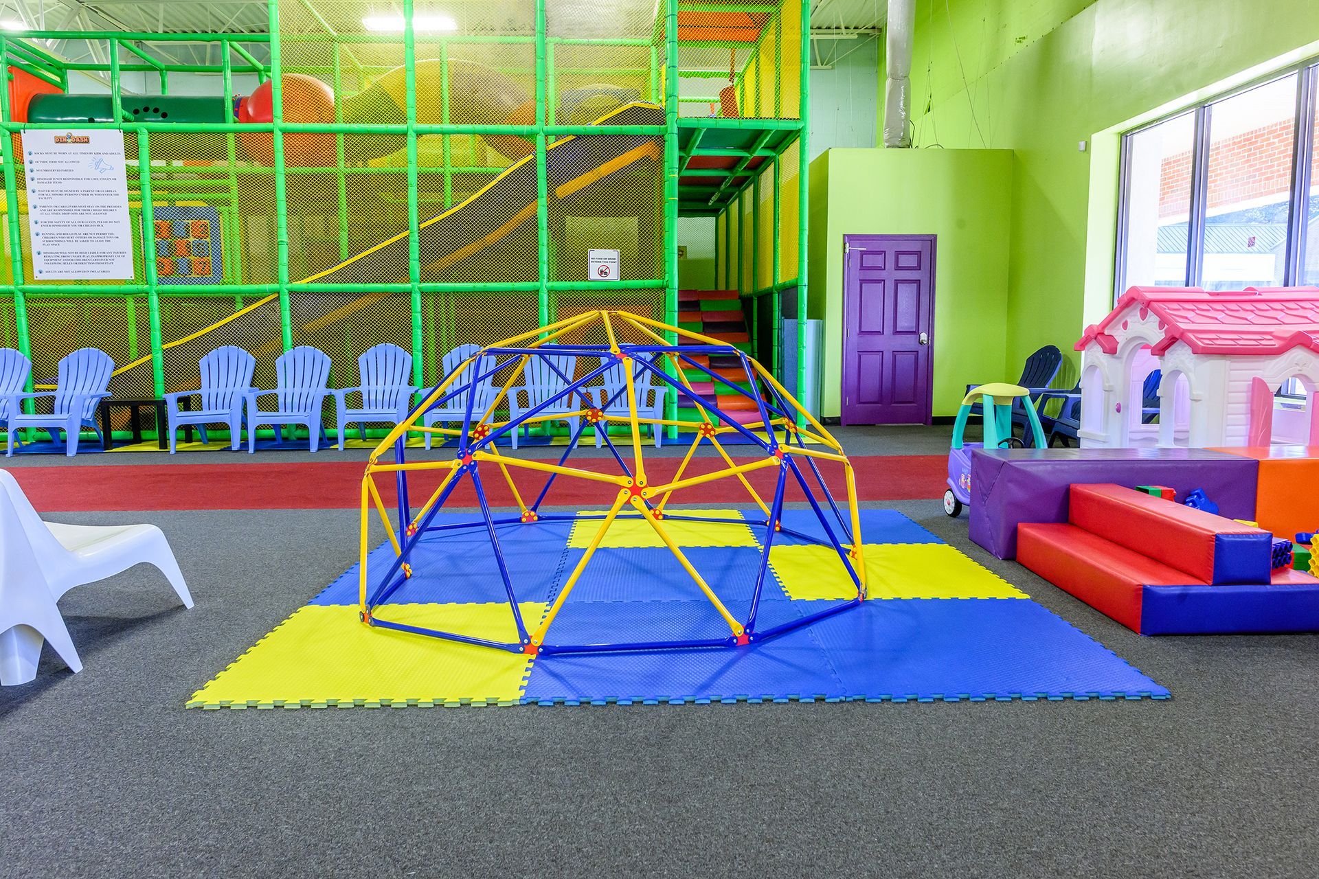 Play area with climbing structure, seating, and playhouse.