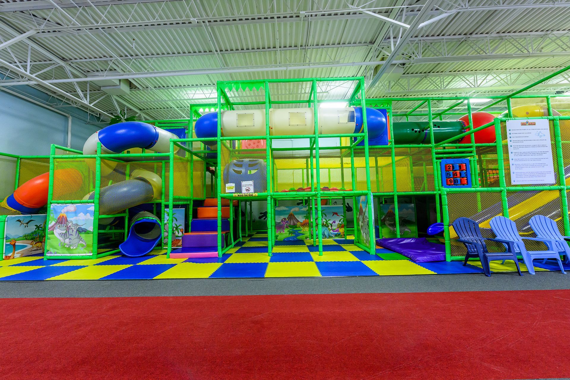 Indoor playground with colorful climbing structure and slides.