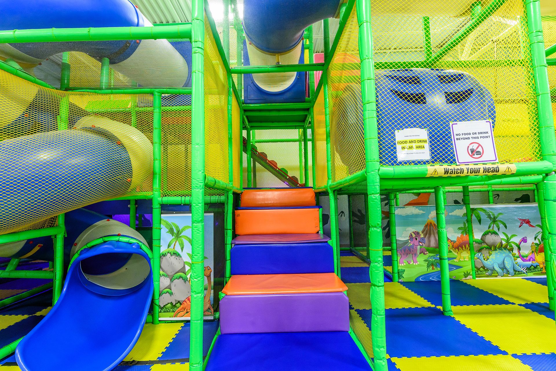 Indoor playground with tunnels, stairs, and a slide.