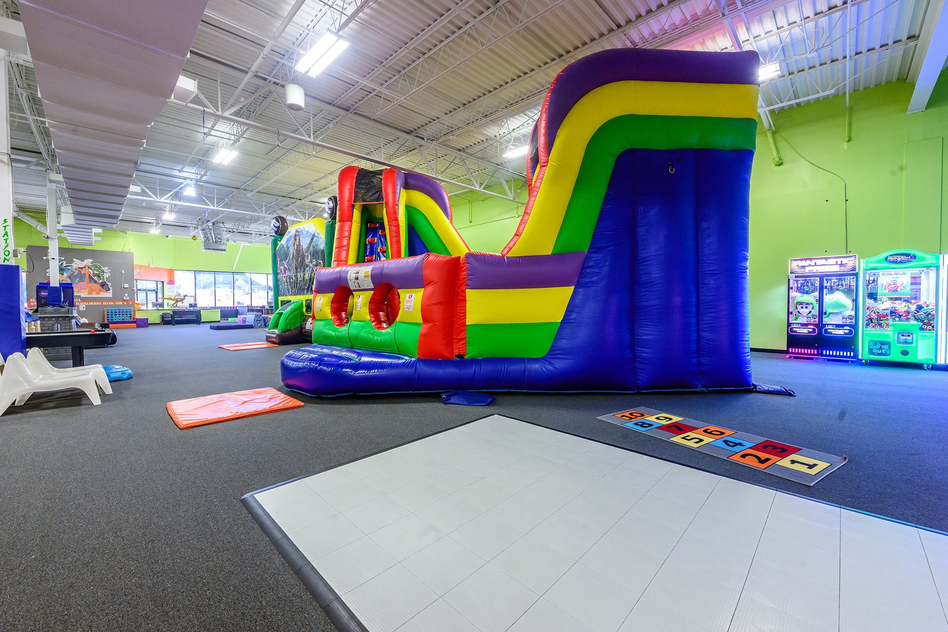 Indoor play area with a large inflatable slide and other play structures.