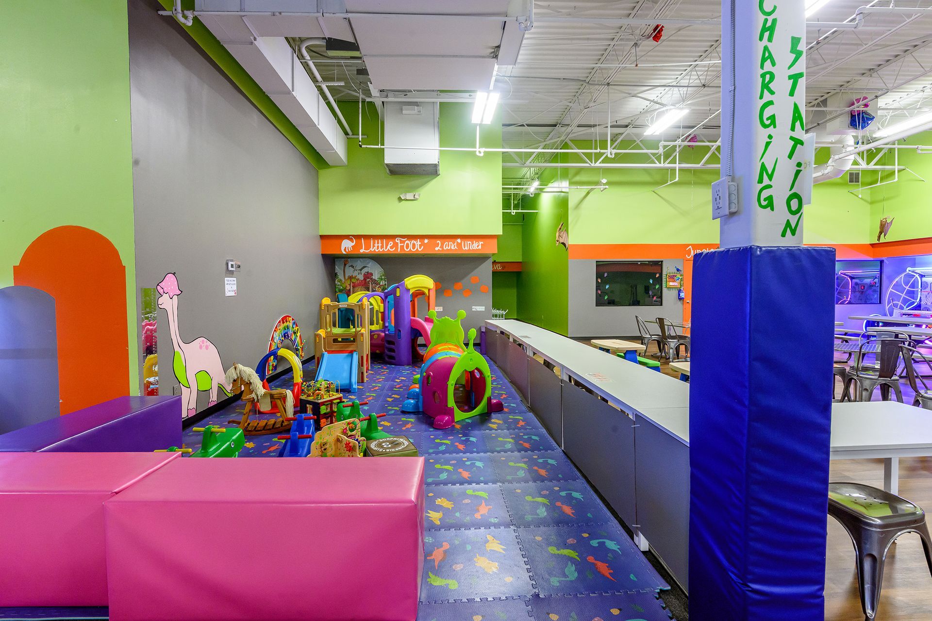 Indoor playground with colorful play structures and cushioned flooring.