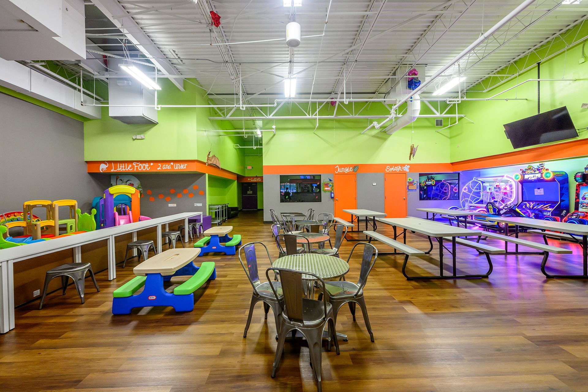 Indoor playground with tables and chairs for parties.