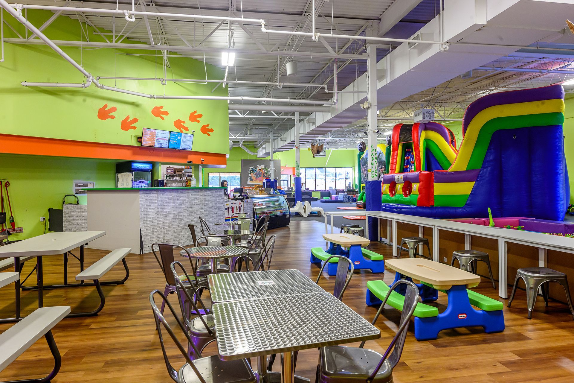 Indoor playground with tables, a bounce house, and concession stand.